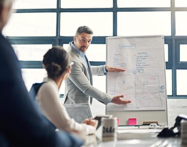 Man, planning and presentation by whiteboard in office for notes, review or invest with crowd. Person, speaker and group for meeting with point, info and training with discussion at property agency.